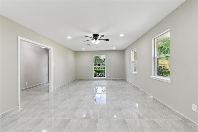 empty room featuring a wealth of natural light and ceiling fan