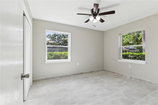 unfurnished room with a wealth of natural light and ceiling fan