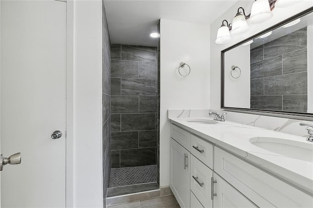 bathroom featuring tiled shower and vanity