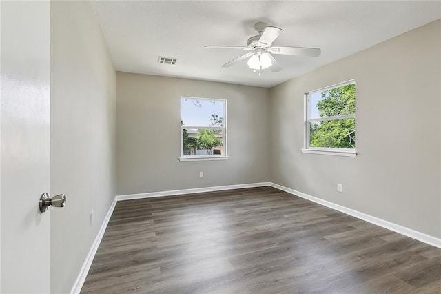 unfurnished room with plenty of natural light, dark hardwood / wood-style floors, and ceiling fan