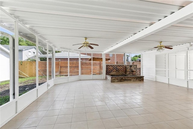 unfurnished sunroom featuring ceiling fan