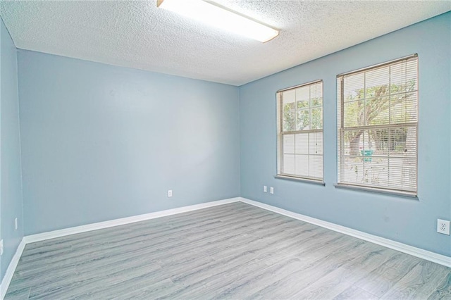 spare room featuring a textured ceiling and light wood-type flooring