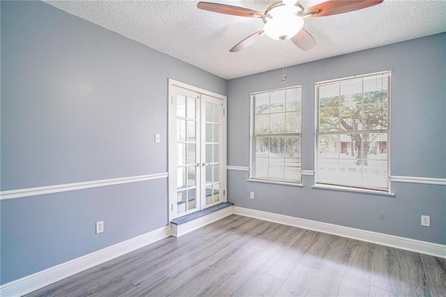 unfurnished room featuring french doors, a textured ceiling, hardwood / wood-style flooring, and ceiling fan