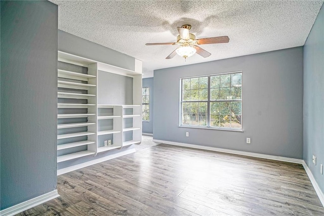 unfurnished room featuring hardwood / wood-style floors, ceiling fan, and a textured ceiling