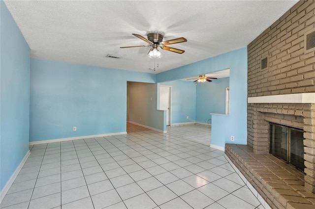 unfurnished living room with a fireplace, light tile patterned floors, a textured ceiling, and ceiling fan