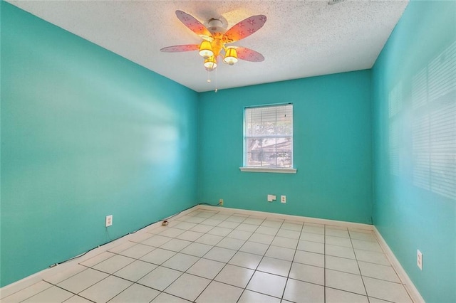 empty room featuring a textured ceiling, ceiling fan, and light tile patterned flooring