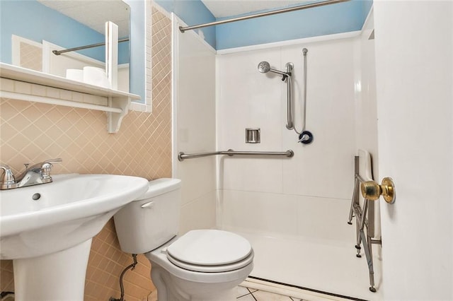 bathroom with a shower, tile patterned flooring, and toilet