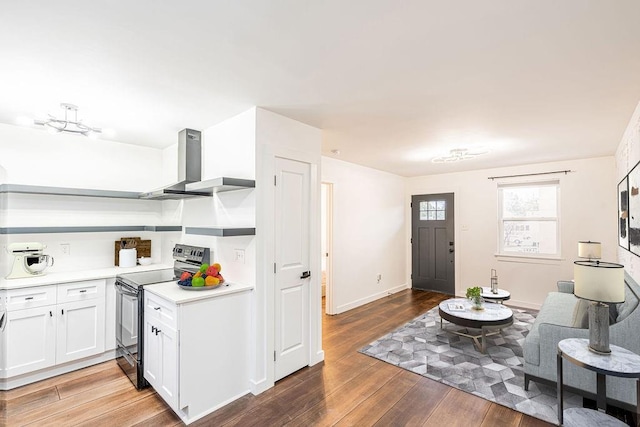 529 Central Ave, Jefferson, LA 70121 - kitchen with range with electric stovetop, wall chimney range hood, light wood-type flooring, light countertops, and white cabinetry