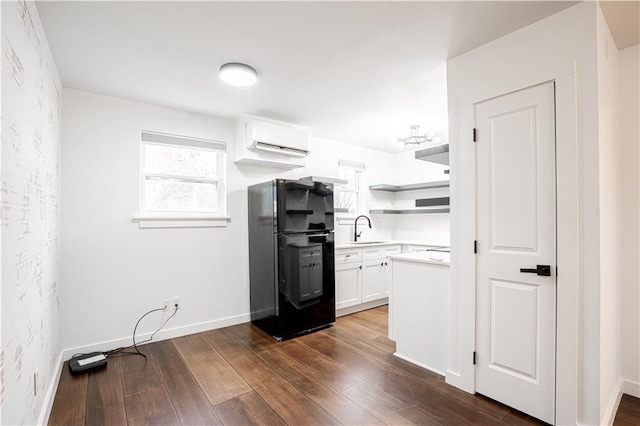 529 Central Ave, Jefferson, LA 70121 - kitchen with freestanding refrigerator, an AC wall unit, a sink, dark wood-style flooring, and white cabinets