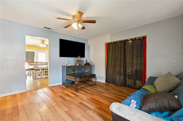 living room featuring ceiling fan and hardwood / wood-style flooring