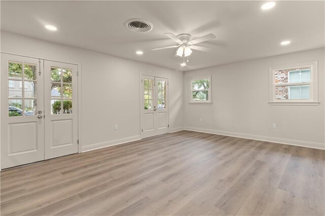 unfurnished room featuring a healthy amount of sunlight, ceiling fan, and french doors