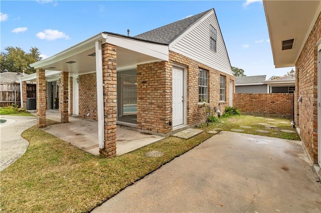 view of side of home with a patio area and central air condition unit