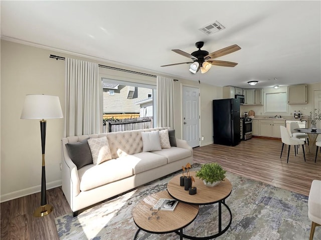 living room featuring ceiling fan, hardwood / wood-style floors, and sink