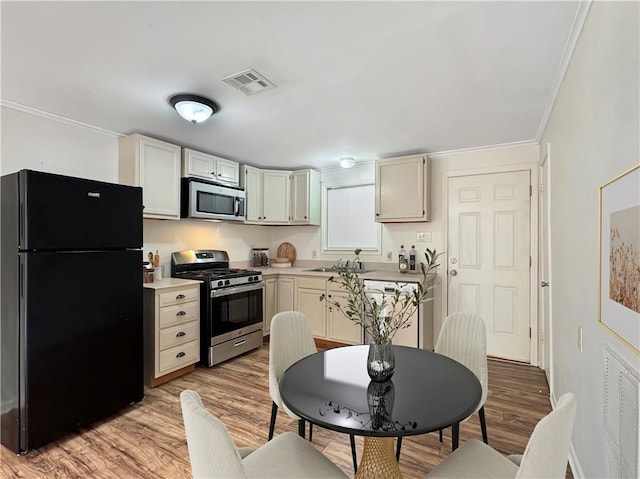 kitchen featuring crown molding, light hardwood / wood-style flooring, stainless steel appliances, and sink