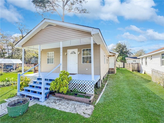 bungalow-style home featuring covered porch and a front yard