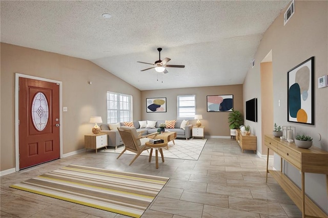 living room featuring ceiling fan, a textured ceiling, and vaulted ceiling