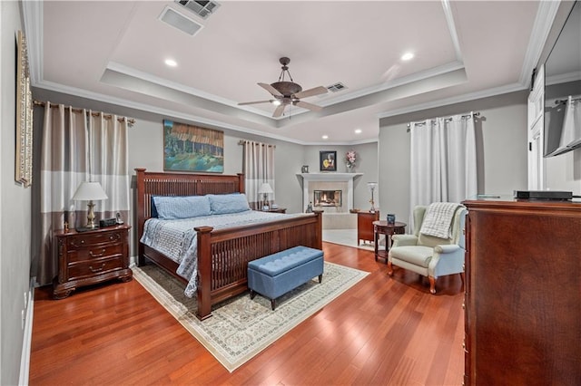 bedroom with a tray ceiling, ceiling fan, and crown molding