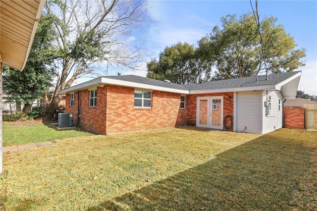 rear view of house featuring a lawn, french doors, and cooling unit