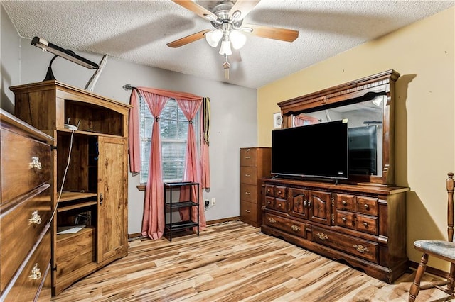 bedroom featuring ceiling fan, light wood-type flooring, and a textured ceiling