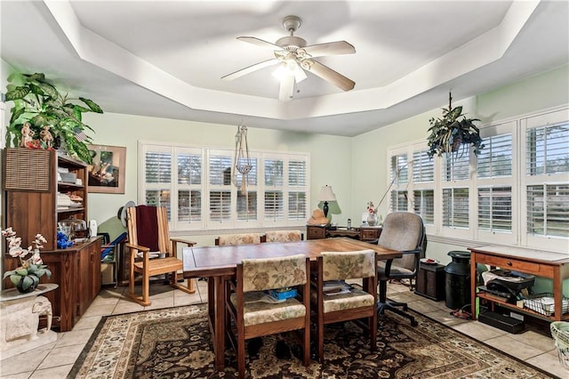 sunroom / solarium featuring a tray ceiling and ceiling fan