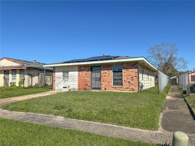 view of front facade with a front lawn and solar panels