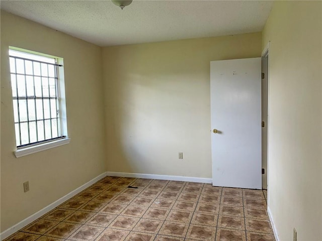 unfurnished room featuring a textured ceiling and plenty of natural light