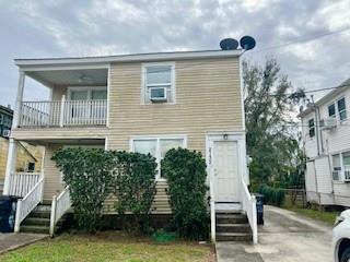 back of property featuring a lawn, cooling unit, and a balcony