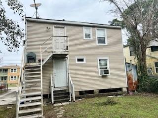 rear view of house with a yard and cooling unit