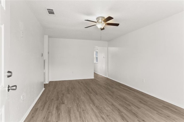 unfurnished room with a textured ceiling, ceiling fan, and dark wood-type flooring