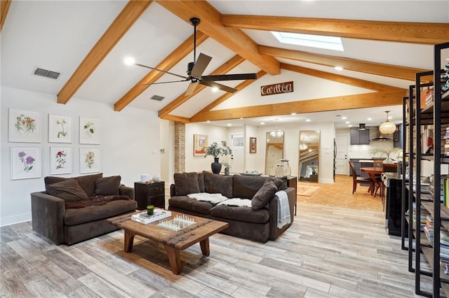 living room featuring ceiling fan, light wood-type flooring, and lofted ceiling with skylight