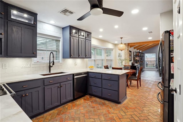 kitchen with kitchen peninsula, appliances with stainless steel finishes, ceiling fan, sink, and hanging light fixtures