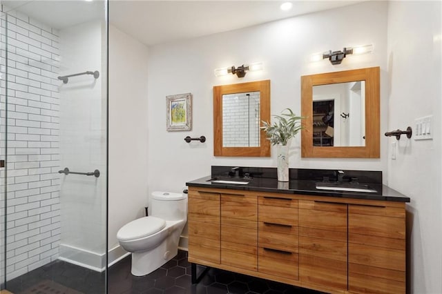 bathroom featuring a tile shower, tile patterned flooring, vanity, and toilet