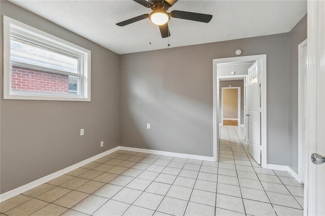 unfurnished room with ceiling fan and light tile patterned floors