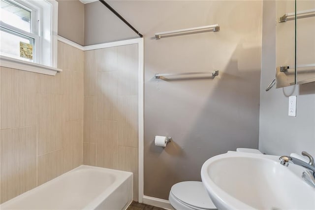 full bathroom featuring toilet, tiled shower / bath, and sink