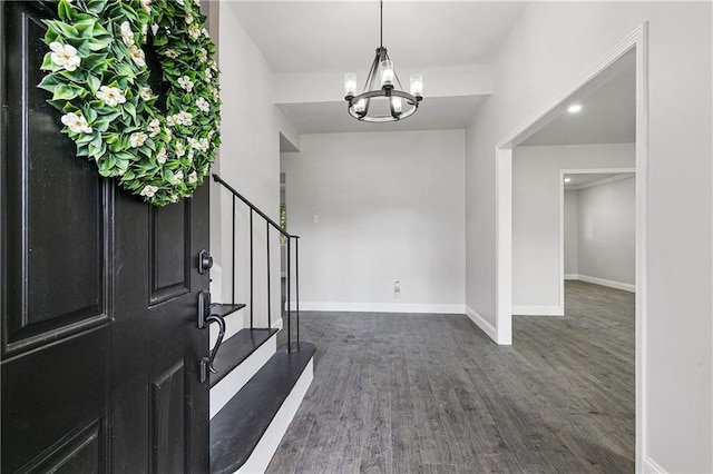 foyer featuring dark wood-type flooring and a notable chandelier