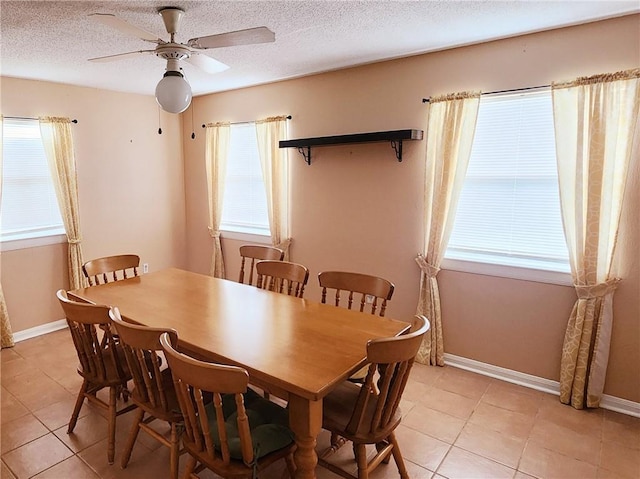 dining room featuring ceiling fan, light tile patterned flooring, and a textured ceiling