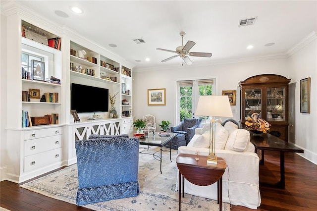 living room with wood-type flooring, ornamental molding, built in features, and ceiling fan