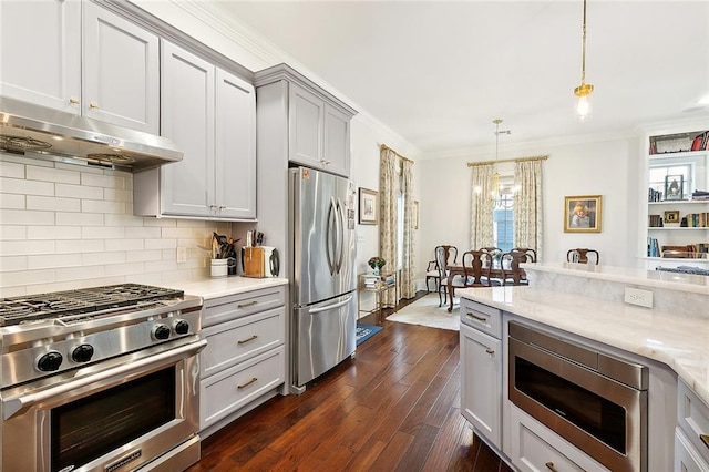 kitchen featuring gray cabinets, stainless steel appliances, ornamental molding, light stone countertops, and decorative light fixtures