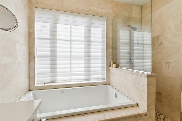 bathroom featuring shower with separate bathtub, plenty of natural light, and tile walls