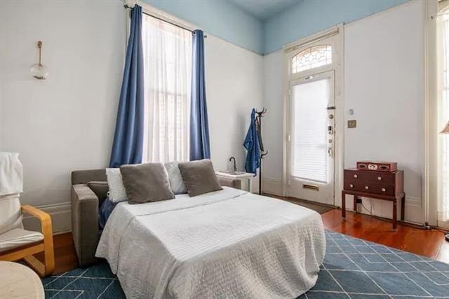 bedroom with dark wood-type flooring and multiple windows