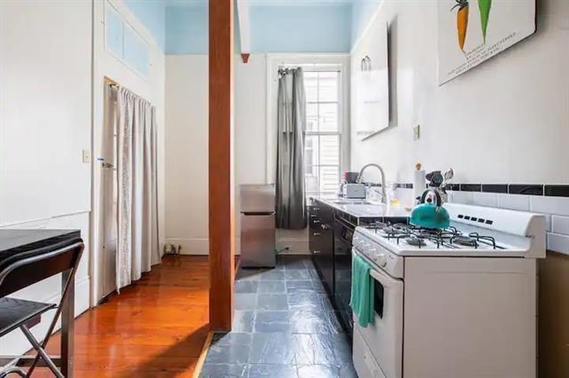 kitchen featuring white cabinetry, gas range gas stove, and sink