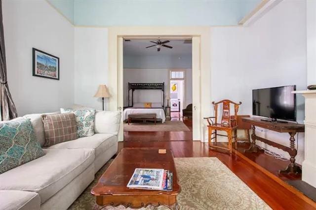 living room featuring dark hardwood / wood-style flooring and ceiling fan