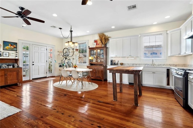 kitchen featuring pendant lighting, white cabinetry, stainless steel gas range oven, and ceiling fan