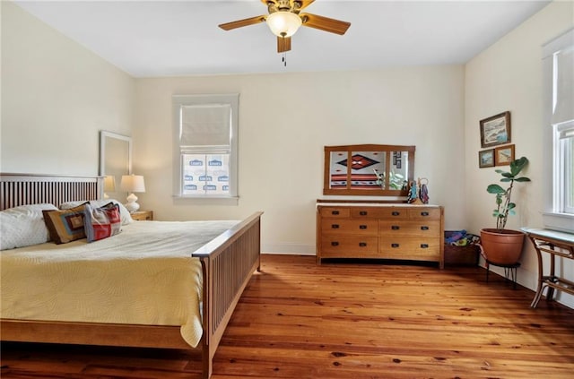 bedroom with multiple windows, light hardwood / wood-style floors, and ceiling fan