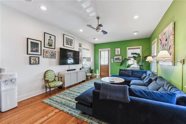 living room with ceiling fan and light hardwood / wood-style flooring