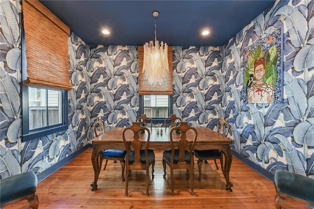 dining area featuring hardwood / wood-style floors and an inviting chandelier