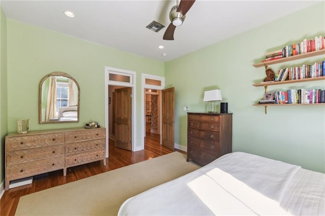 bedroom with dark hardwood / wood-style flooring and ceiling fan