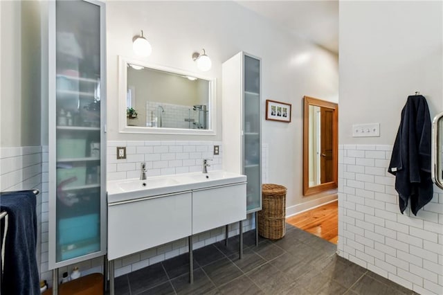 bathroom with tile patterned flooring, vanity, and tile walls