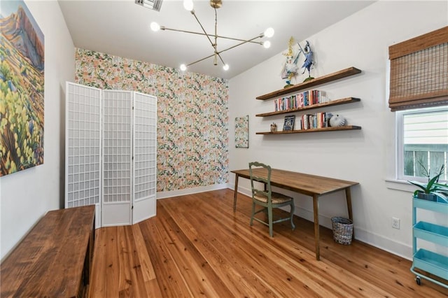 home office with hardwood / wood-style floors and a chandelier