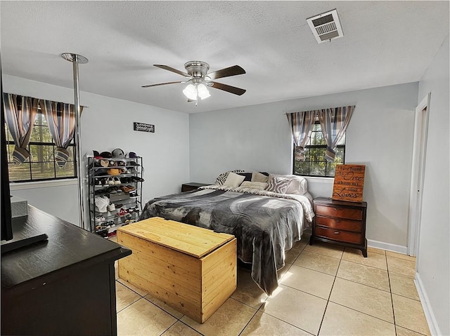 bedroom featuring light tile patterned floors, a textured ceiling, and ceiling fan